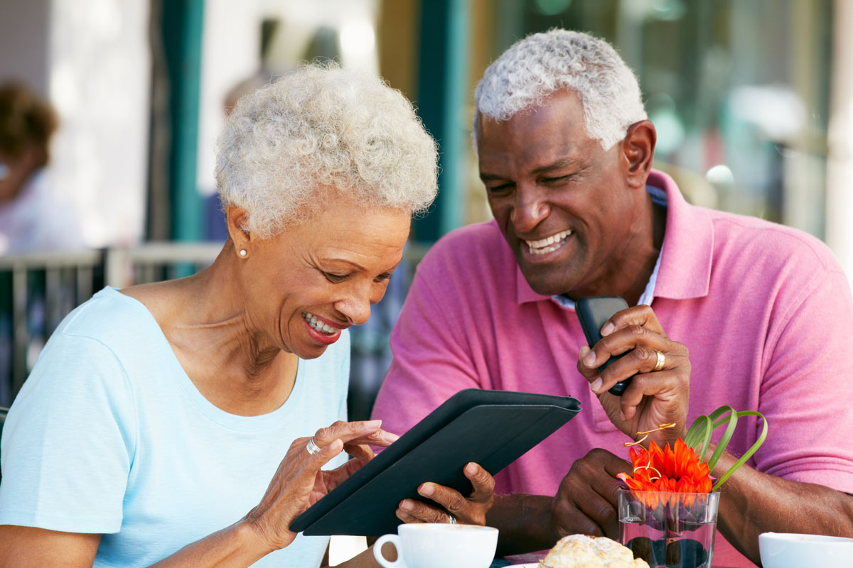 senior couple on a tablet together during a meal