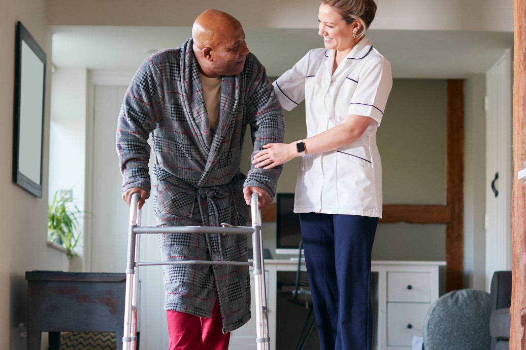 Female healthcare worker assisting a senior male with crutches during rehab